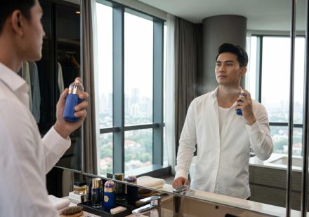 seorang pria sedang grooming menggunakan parfum mykonos