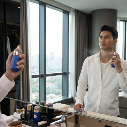 seorang pria sedang grooming menggunakan parfum mykonos