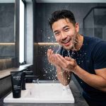 seorang pria sedang mencuci muka dengan skincare pria